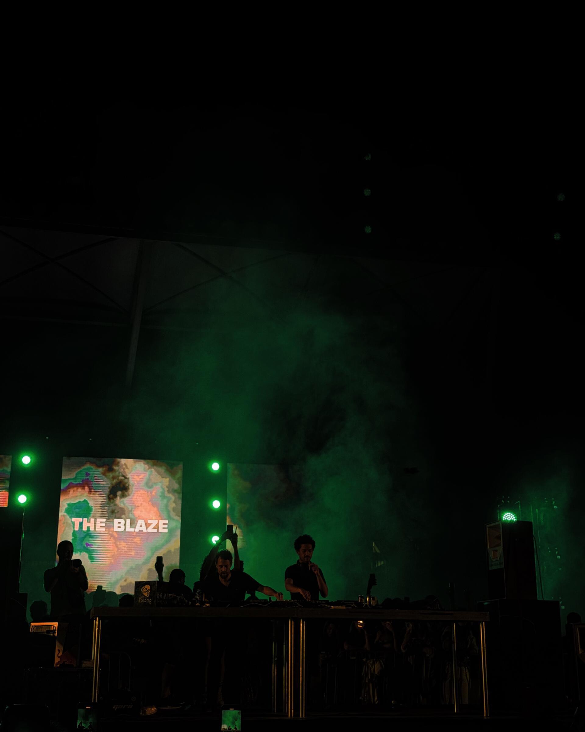 The Blaze, green stage light and haze at a night concert in Baku